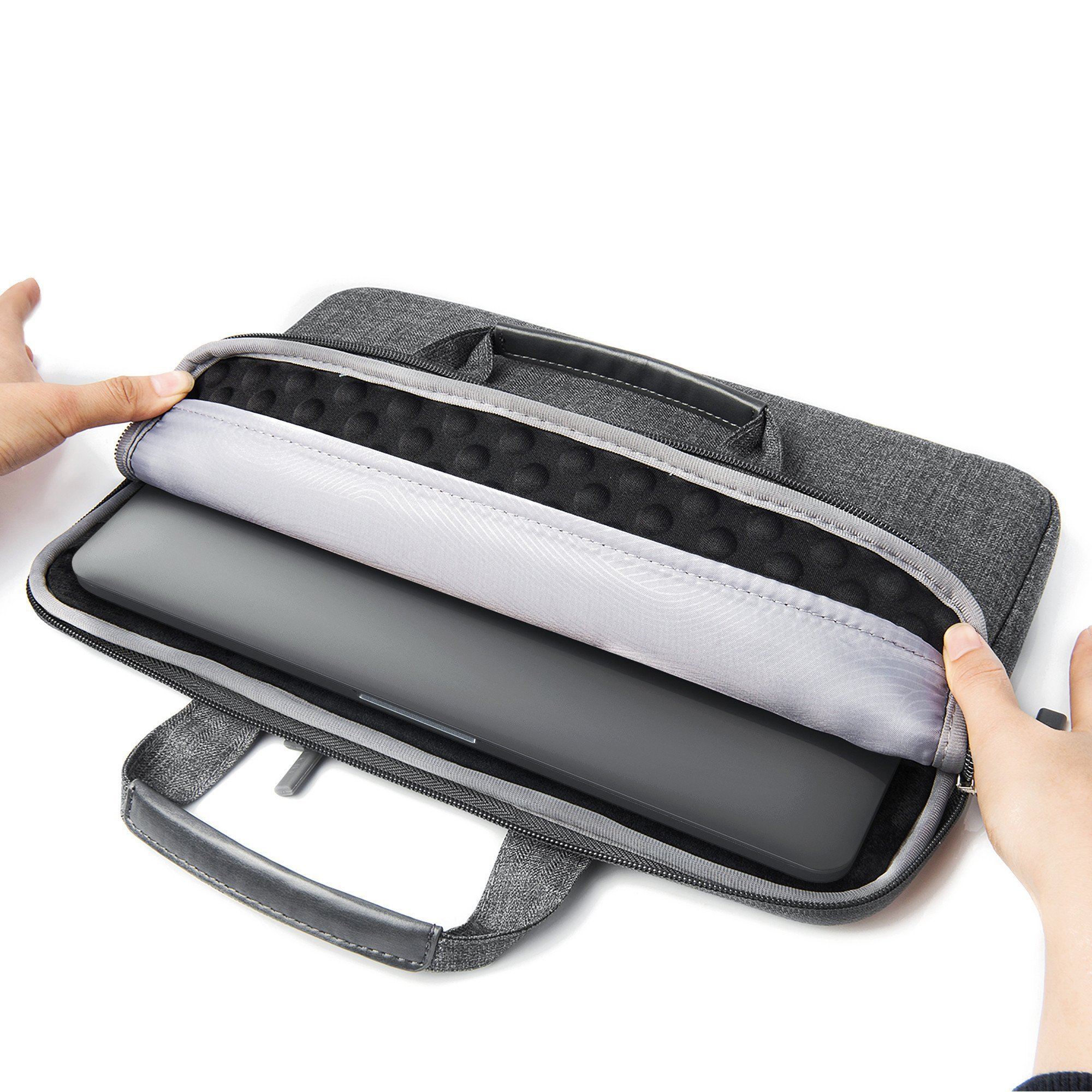 Mani che aprono una custodia grigia per laptop con un laptop all'interno.