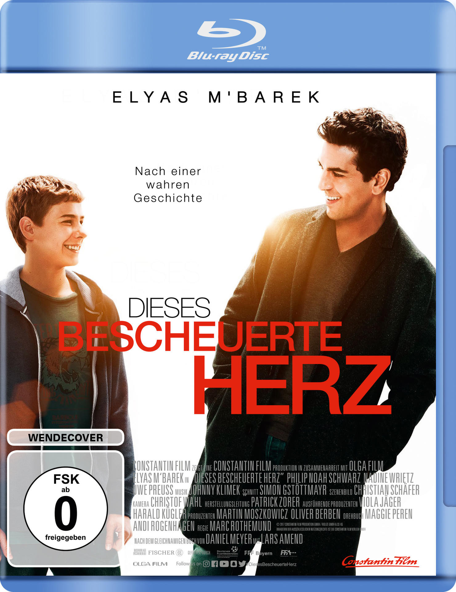 Filmposter, zwei Männer, einer lächelt, mit Text auf Deutsch.