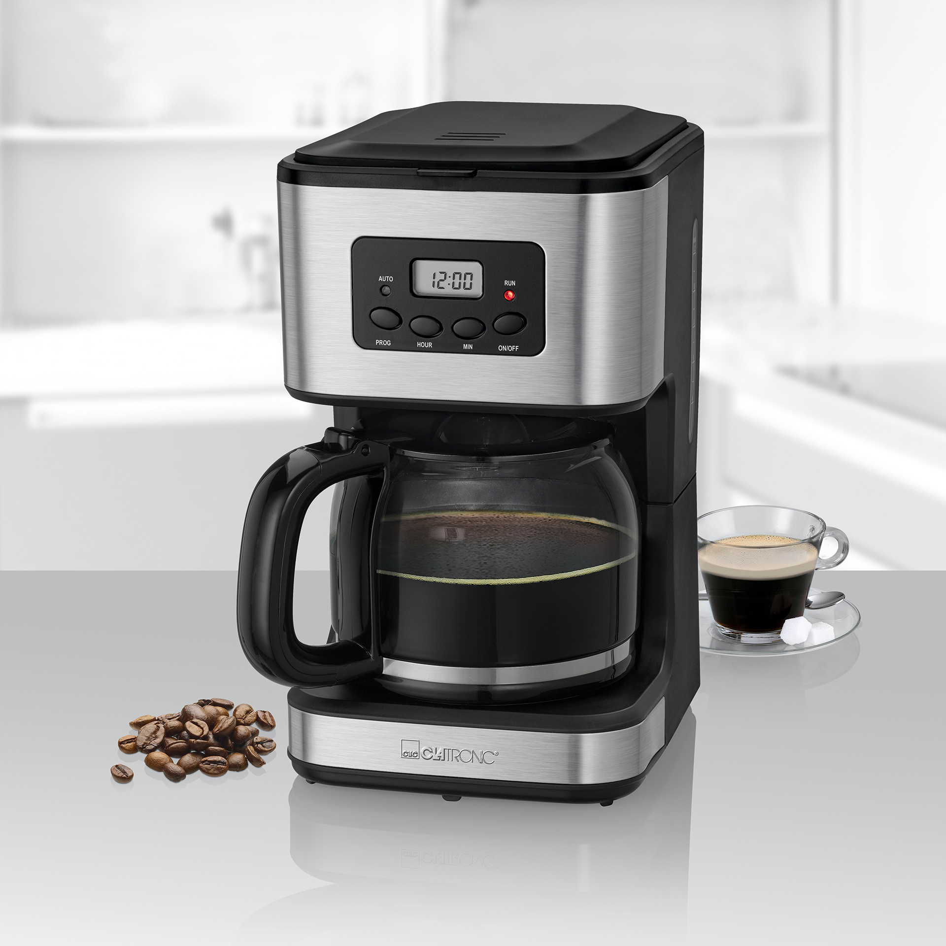 Kaffeemaschine mit Kaffee und Bohnen, schwarz und silber, mit einer Glastasse.