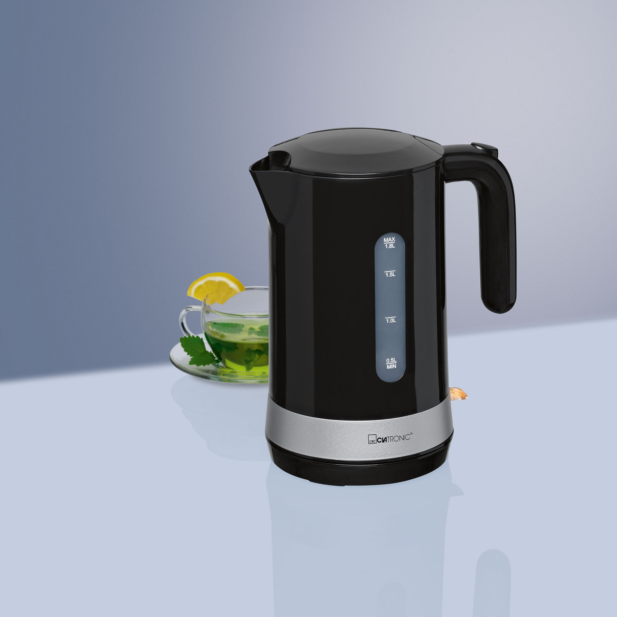 Ein schwarzer Wasserkocher mit silbernen Akzenten und einem schwarzen Griff, daneben eine Tasse Tee mit Zitrone.