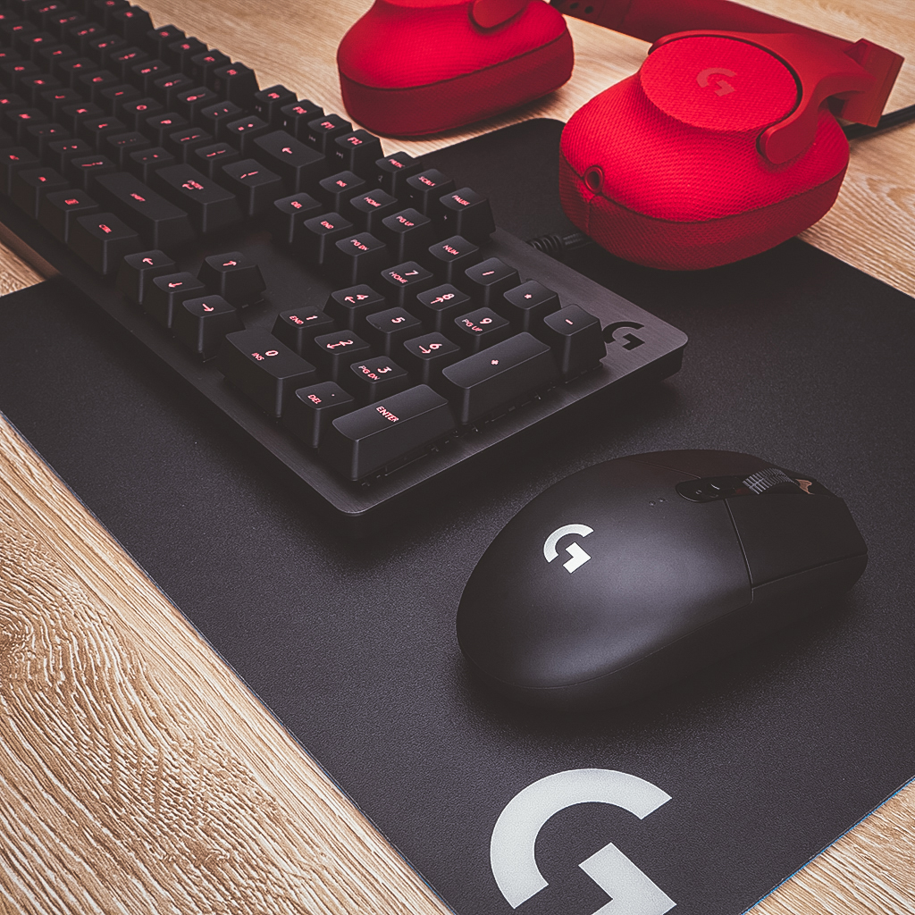 Gaming-Setup: Tastatur, Maus, Mauspad und Kopfhörer.