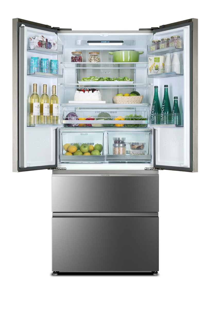 Offener Kühlschrank mit Lebensmitteln gefüllt: Flaschen, Dosen, Kuchen, Obst, Gemüse und Gläser. Unten sind zwei Schubladen.