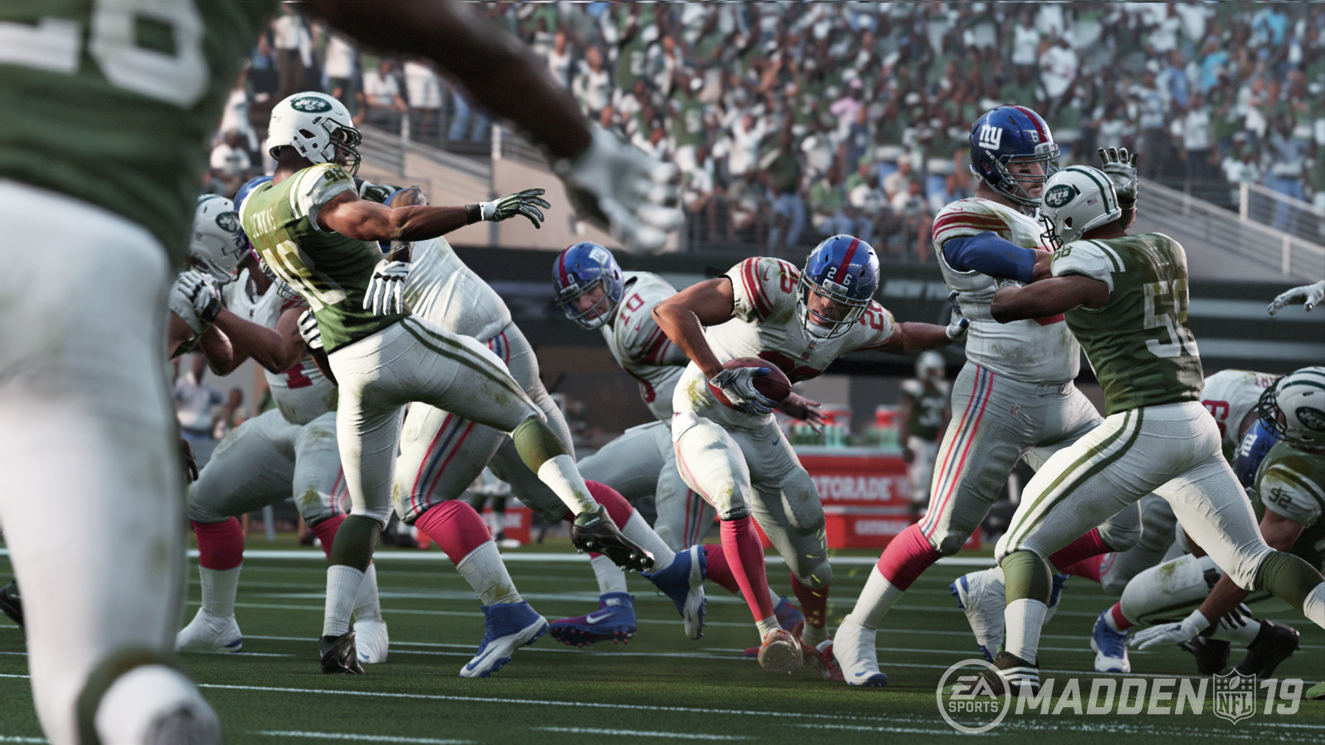 Ein Screenshot des Spiels Madden NFL 19. Footballspieler in Aktion, mit grünen, weißen und blauen Uniformen.