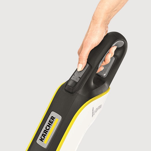 Hand hält einen Kärcher Staubsauger. Der Staubsauger ist schwarz und gelb mit ein paar Knöpfen.