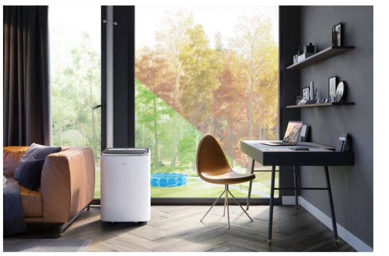 Innenansicht eines Raumes mit Luftreiniger, Schreibtisch und Fensterblick.