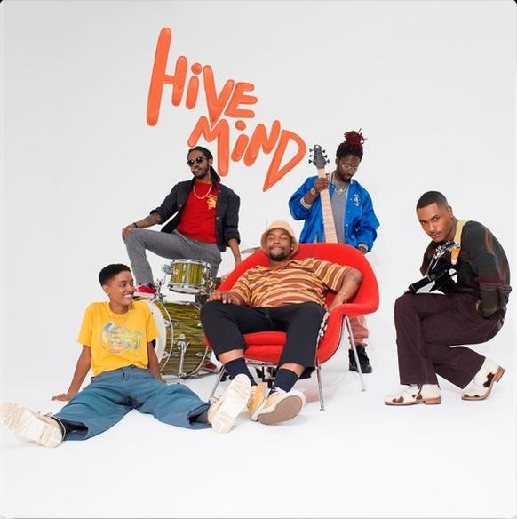 Fünf Leute posieren für ein Foto. Das Wort 'Hive Mind' steht oben in Orange.