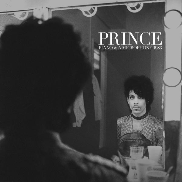 Schwarz-Weiß-Foto von Prince. Er steht vor einem Spiegel.