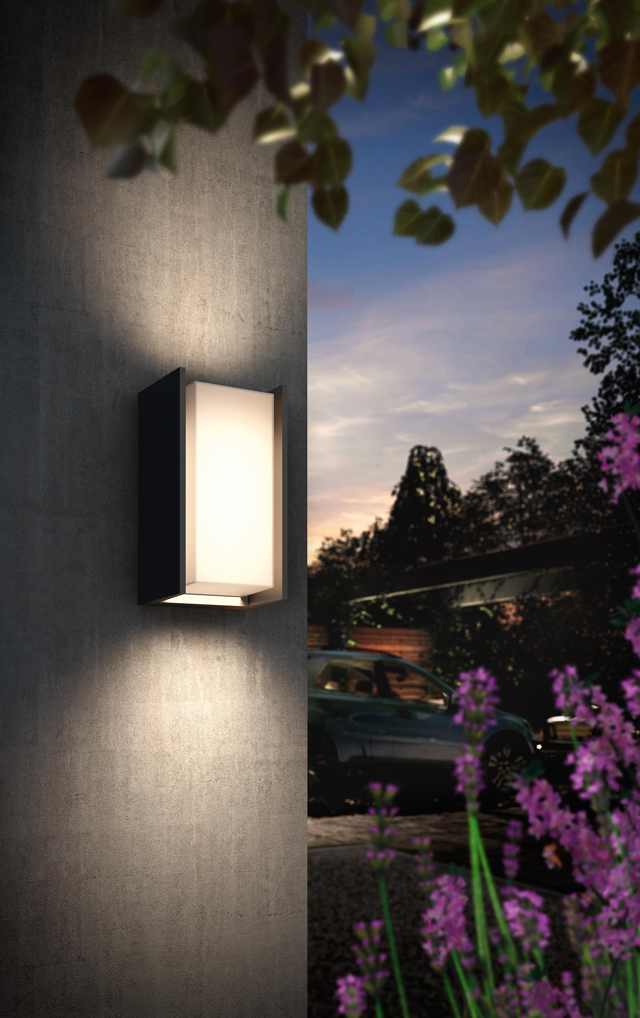 A lit wall light on a textured wall, with trees and a car in the background.