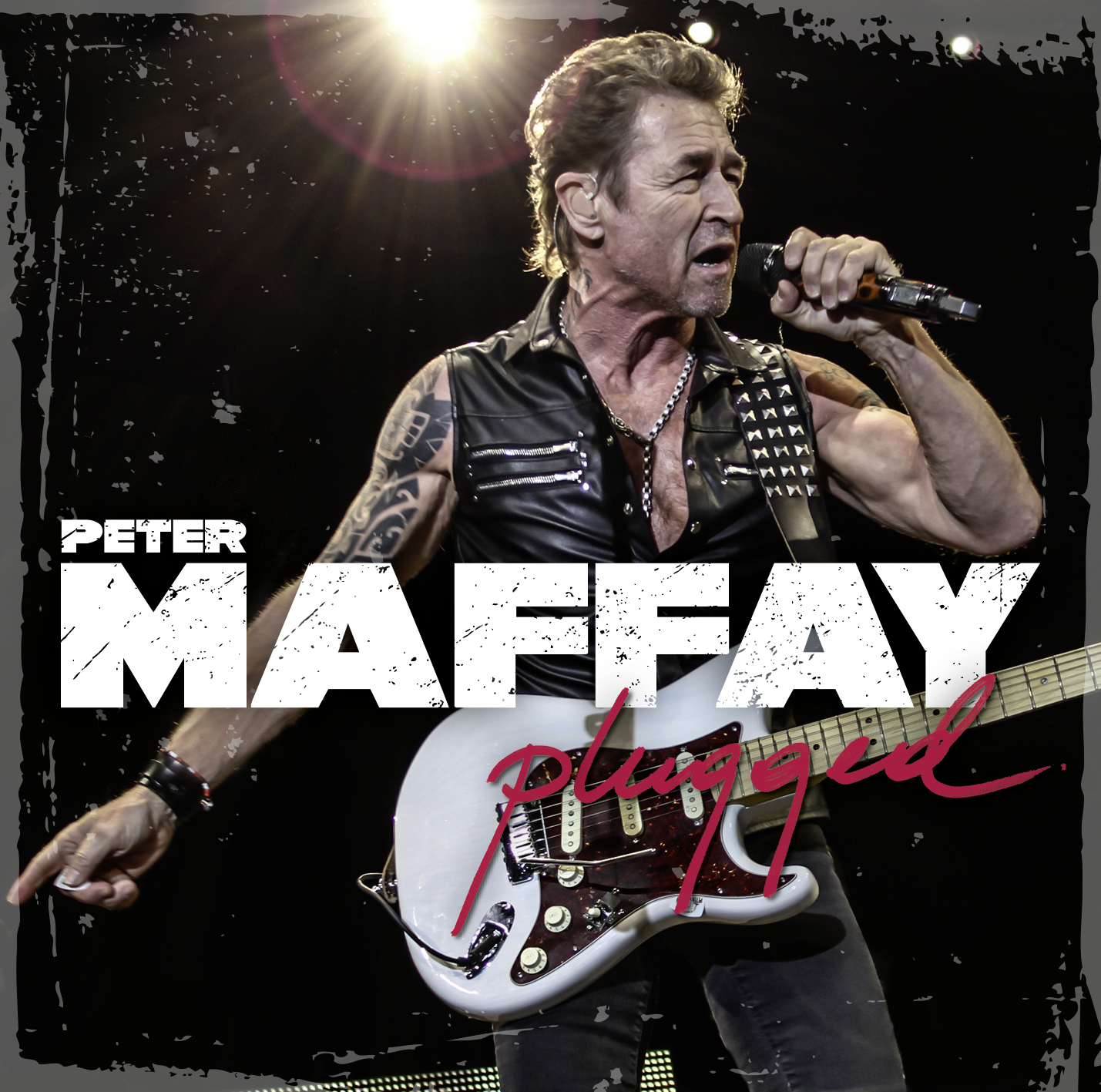 Peter Maffay singt in ein Mikrofon, hält eine Gitarre, mit 'Plugged' Text.