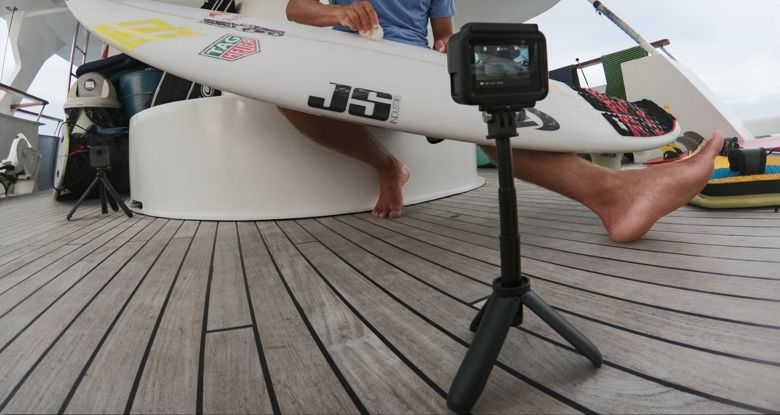 Een surfer met een surfplank op een jacht, gefilmd door een GoPro op een statief.