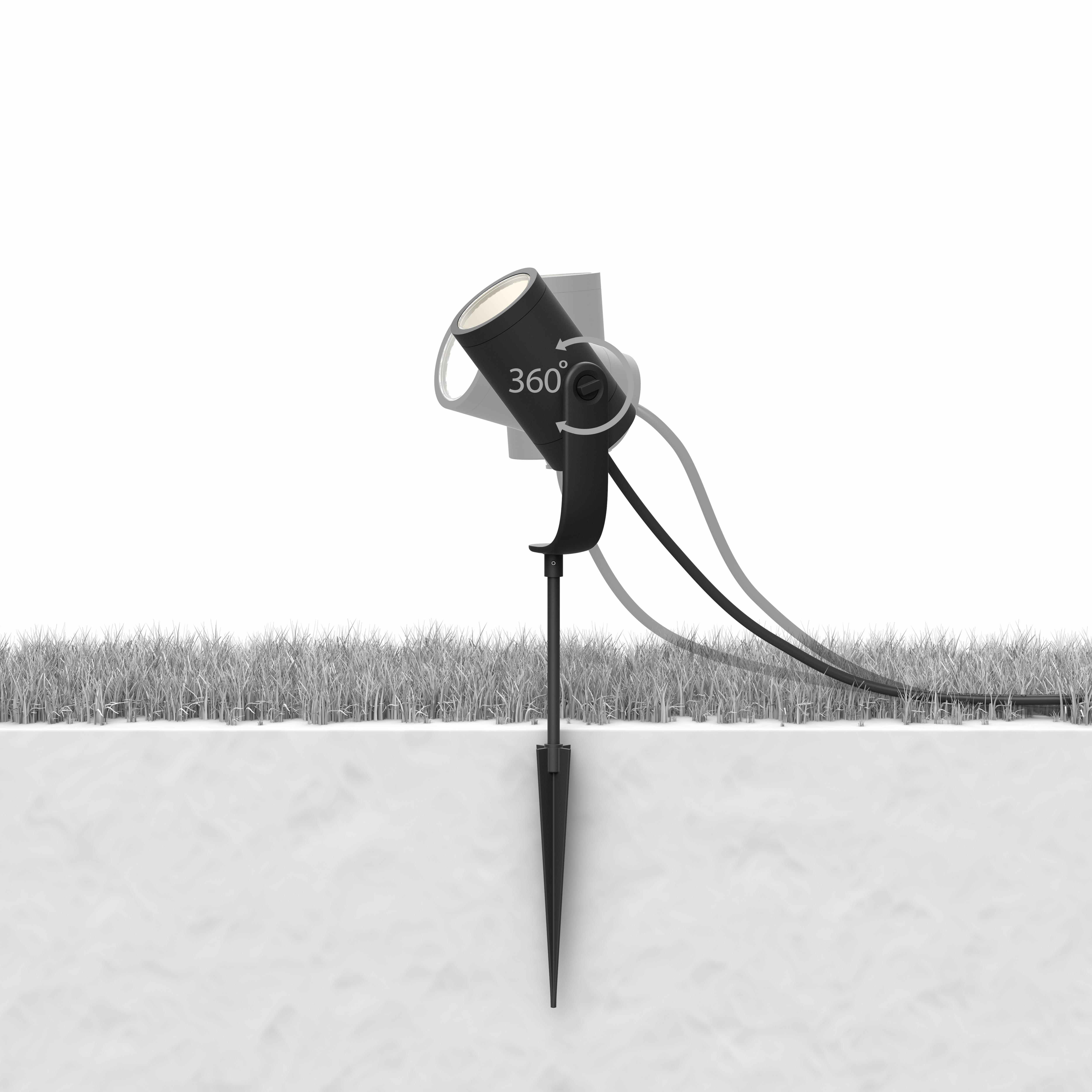 A black outdoor spotlight on a spike, angled towards a white background.