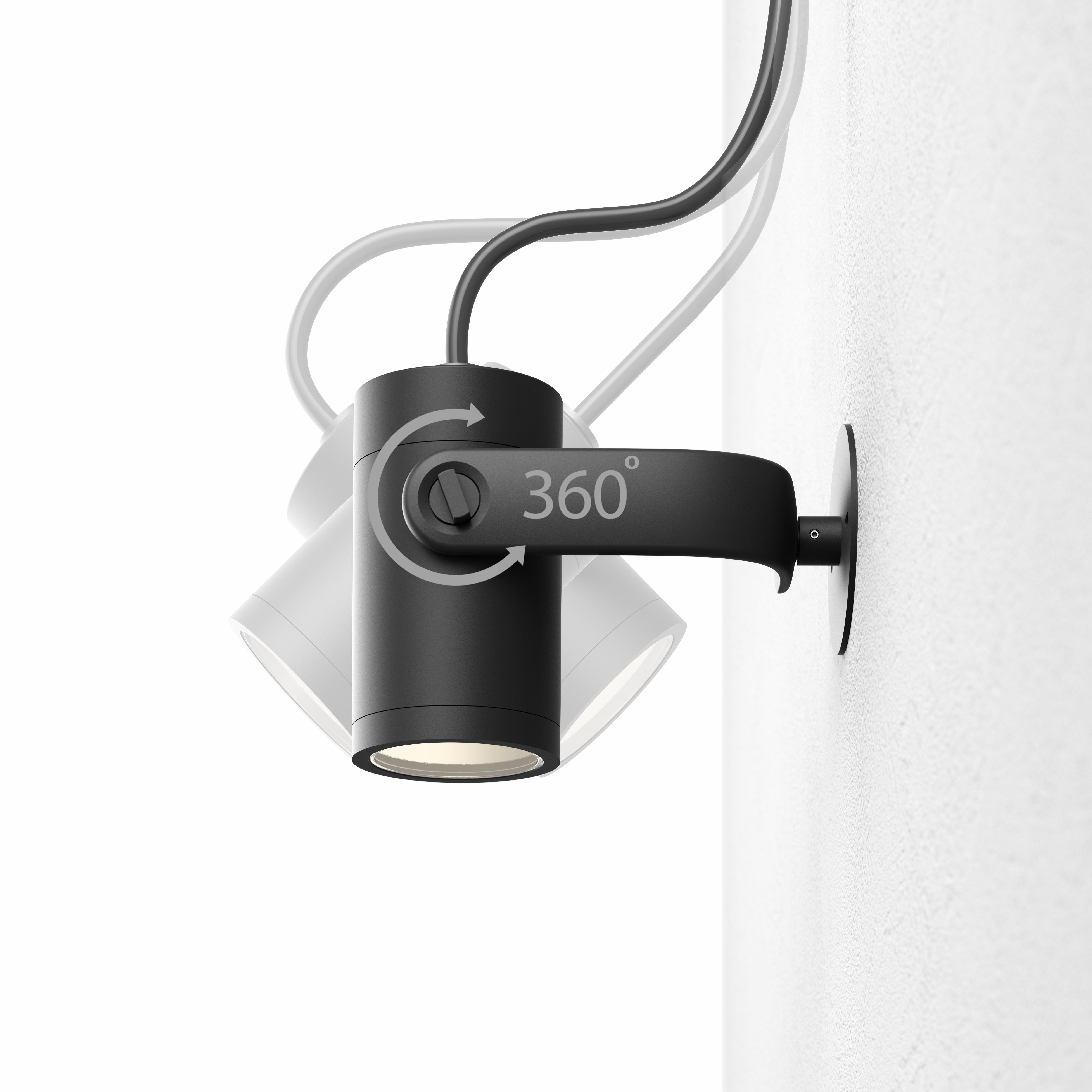 Black spotlight on white wall, rotating with 360°.