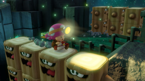 Un personnage de Toad courant sur des blocs de bois dans une scène de jeu vidéo. Il y a des lumières vives.