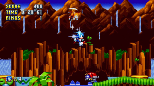 Una scena di videogioco con Sonic the Hedgehog che corre e salta. Colline verdi e cascata.