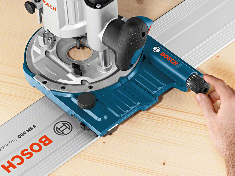 Kék-szürke szerszám faanyagon. Kéz beállítja a beállítást. Bosch logó látható.