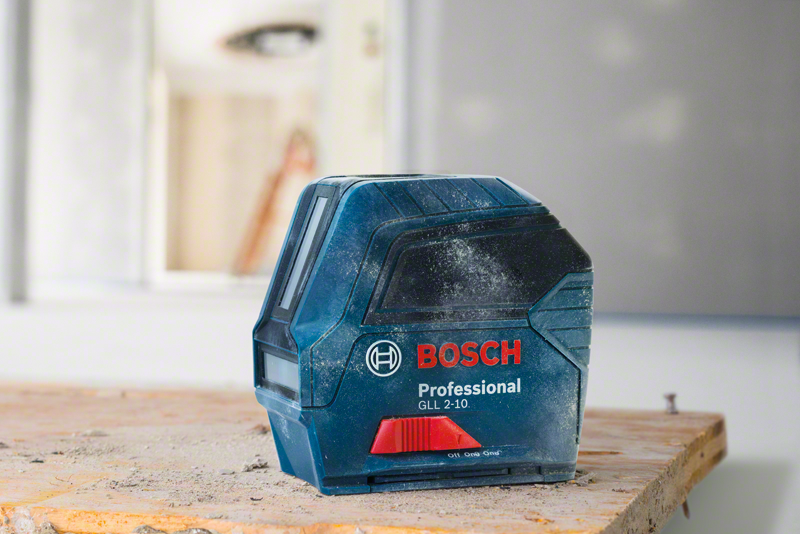 Kék-fekete Bosch lézeres szintező fa felületen. Háttér: elmosódott belső tér.