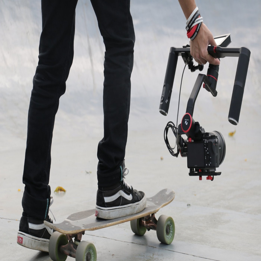 A person on a skateboard holding a video camera stabilizer with a camera attached.