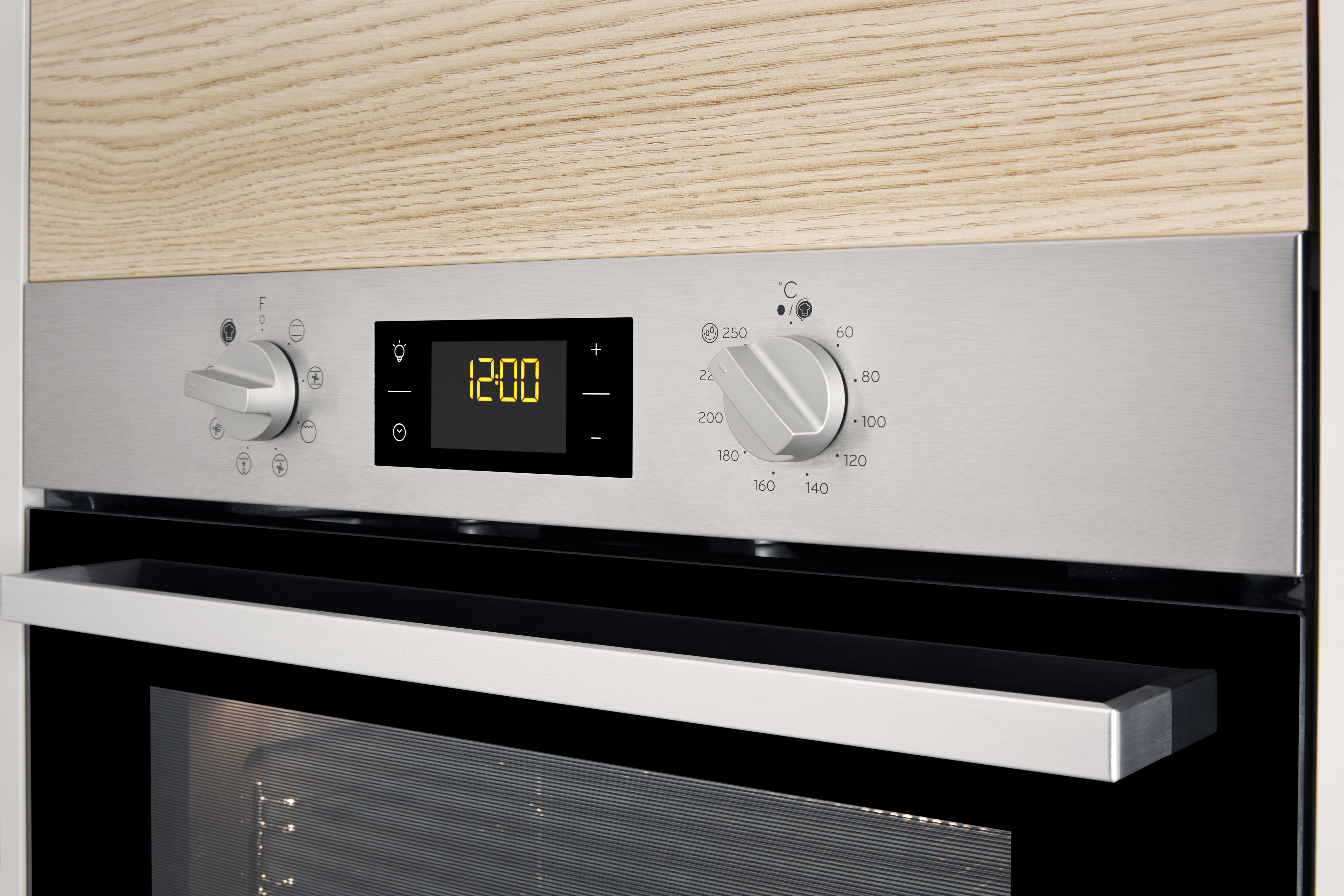 Ein Backofen-Bedienfeld mit Knöpfen, digitaler Uhranzeige und einem silbernen Griff darunter.
