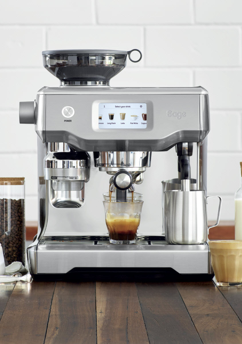 Silberne Espressomaschine, die Kaffee in ein Glas brüht, mit Kaffeebohnen und Milch.