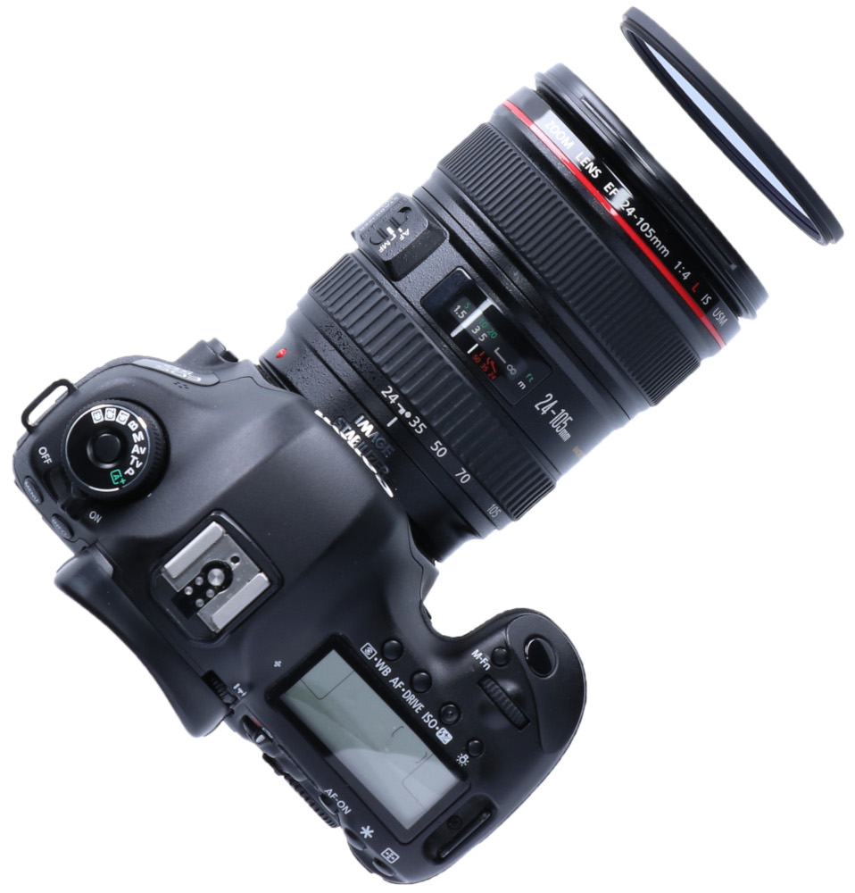 Un appareil photo Canon avec objectif et un filtre d'objectif devant. Fond blanc.