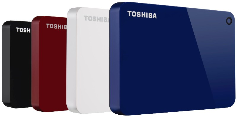 Cuatro discos duros externos Toshiba en negro, rojo, blanco y azul, uno junto al otro.
