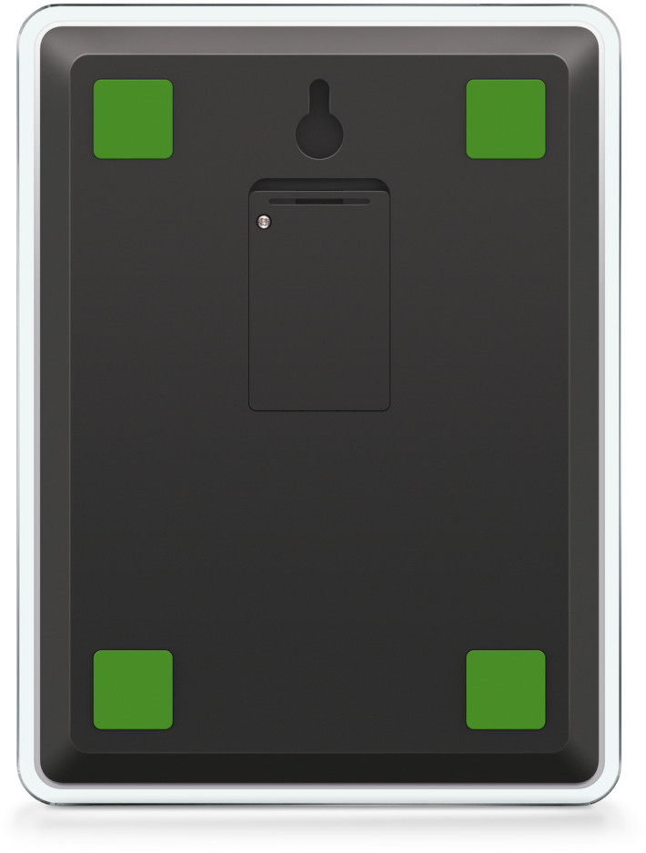 Un appareil rectangulaire noir avec des coussinets carrés verts à chaque coin. Un trou et un renfoncement pour une batterie sont visibles.