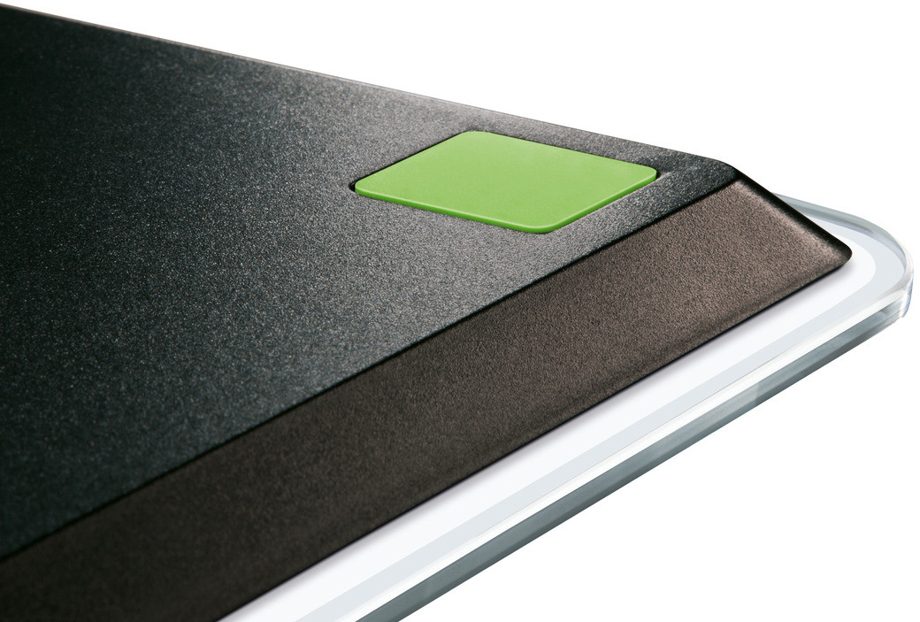 Balance électronique noire et verte, gros plan sur le coin.