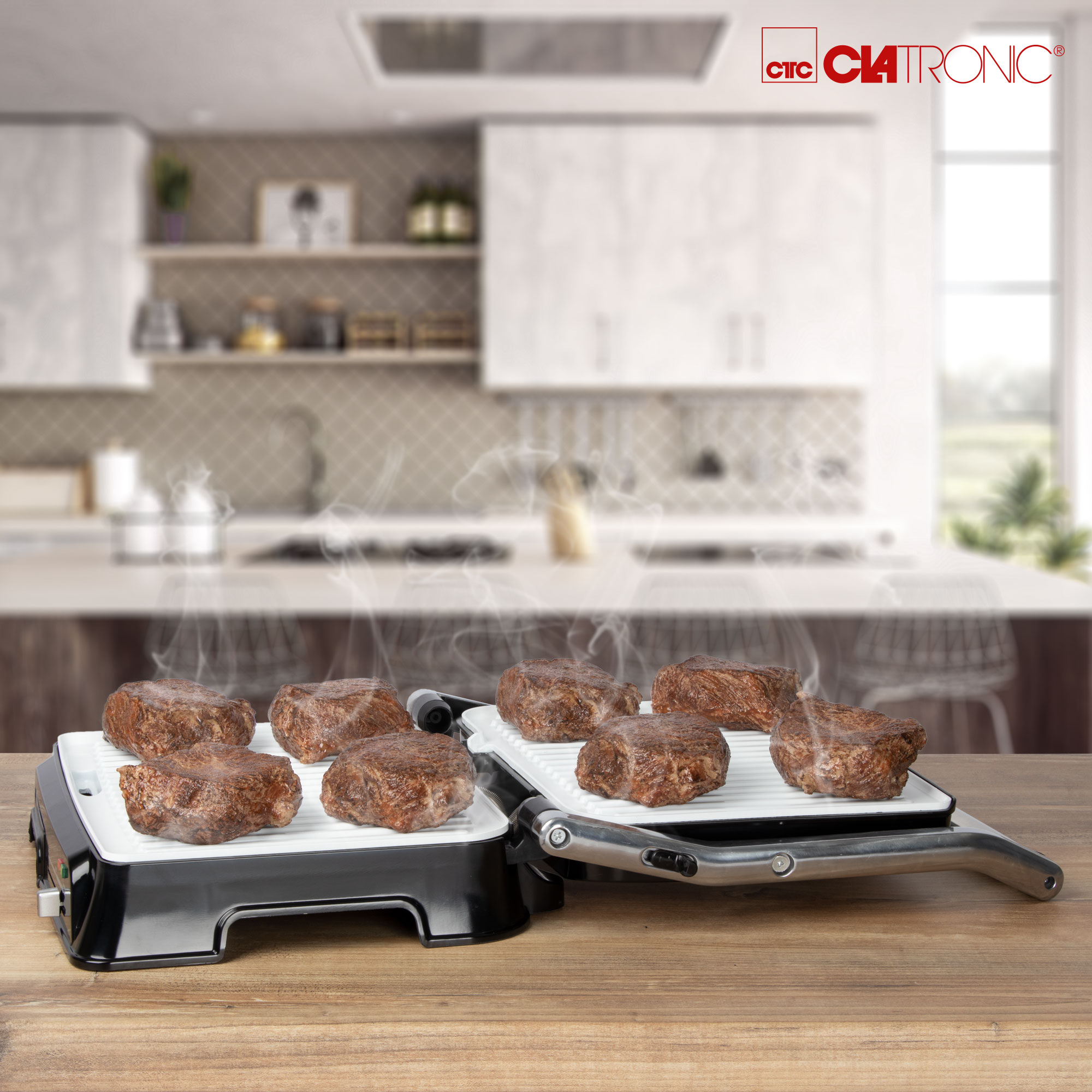 Steaks werden auf einem CIATRONIC-Grill gebraten. Dampf steigt auf, weiße und schwarze Oberfläche.