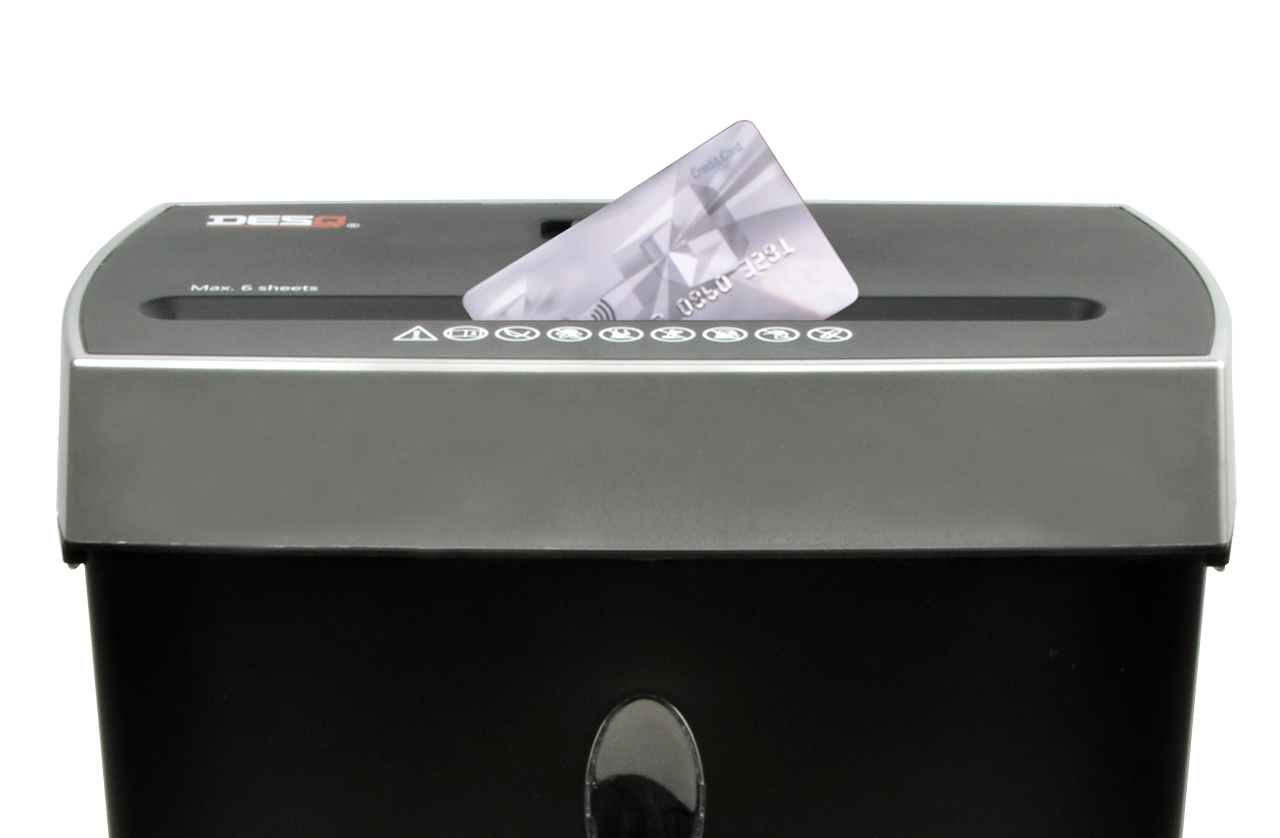 A credit card being shredded in a black and gray paper shredder.
