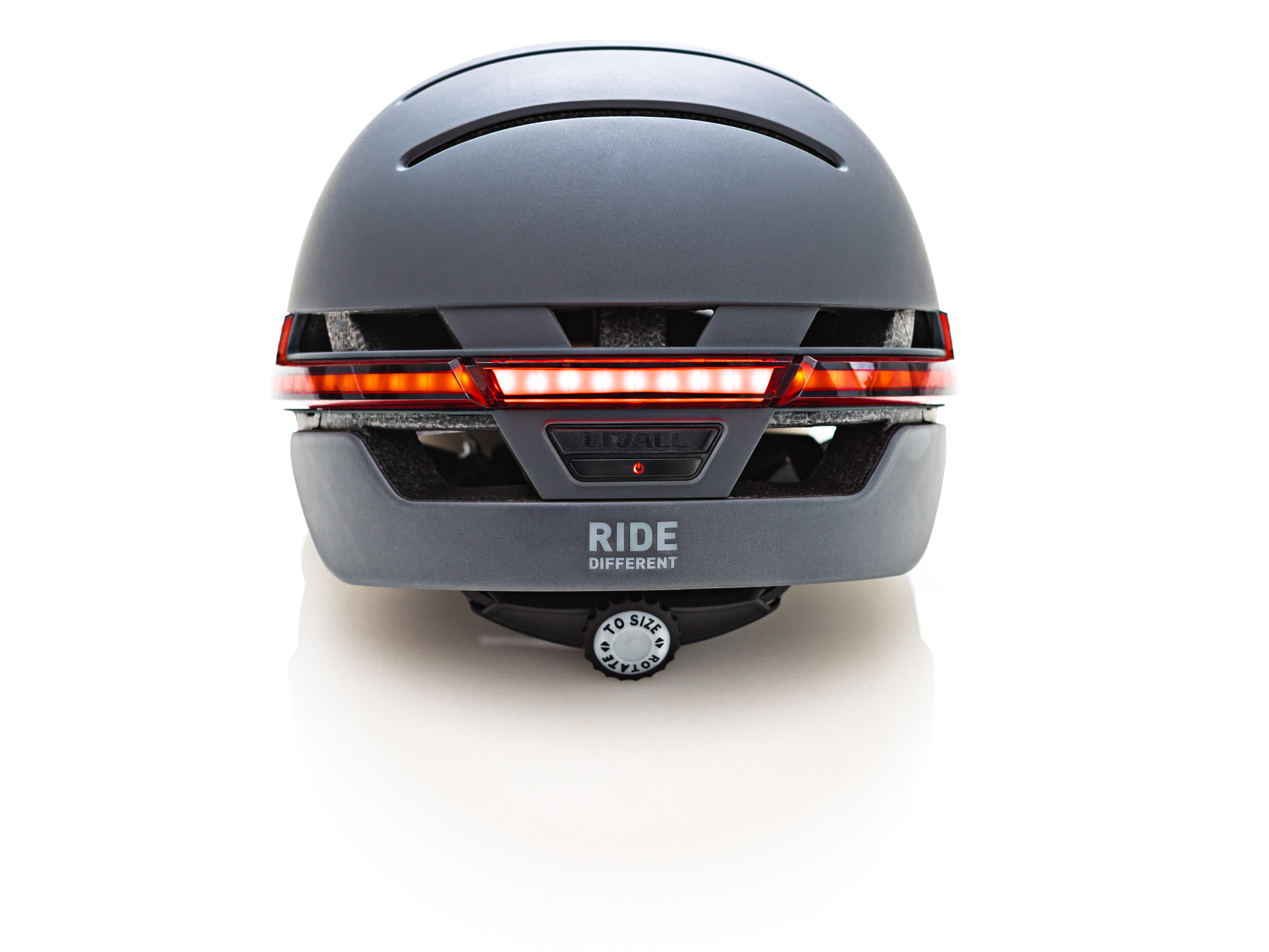 Ein grauer Fahrradhelm mit rotem Lichtbalken. Auf dem Helm steht das Wort 'RIDE'.