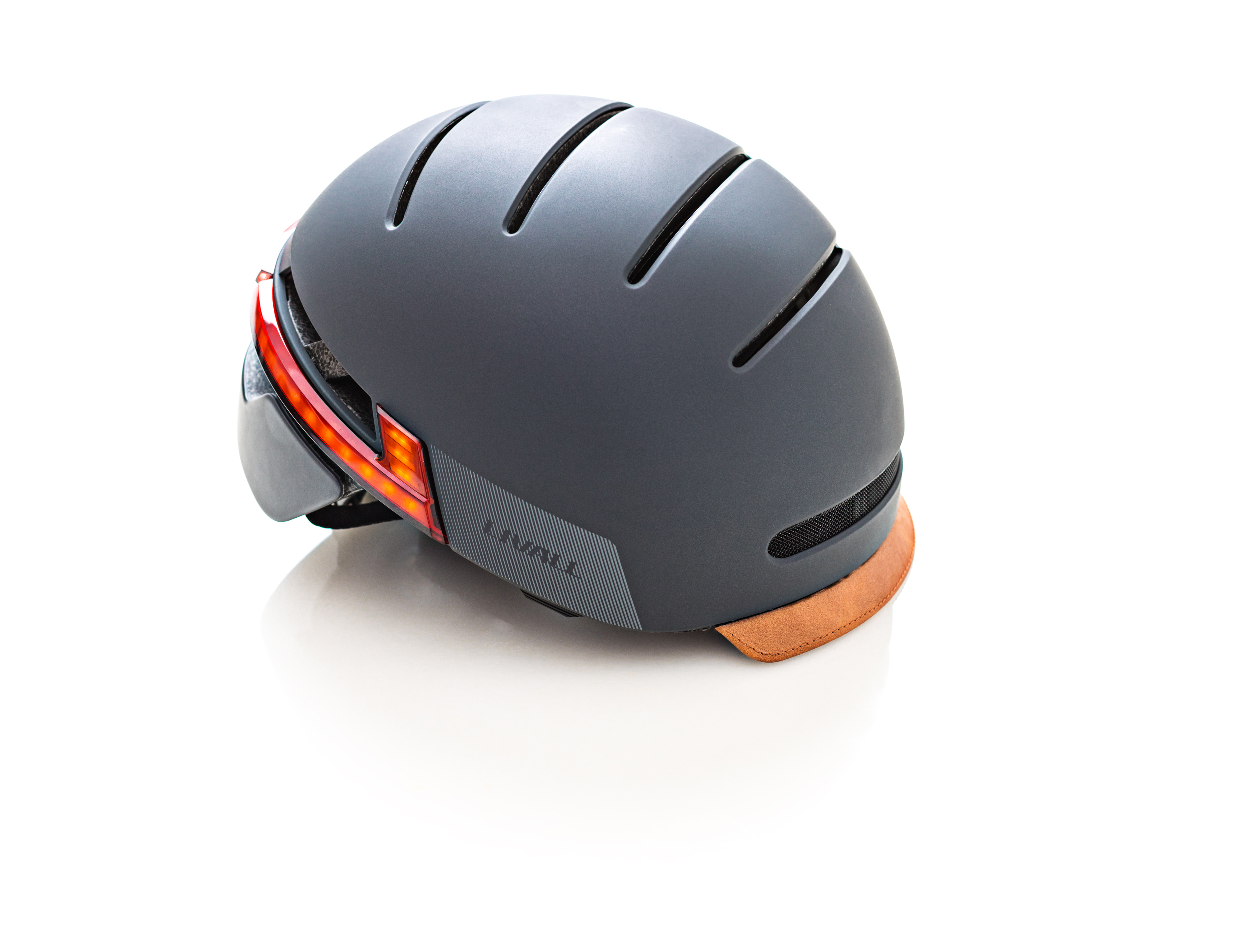 Ein grauer Fahrradhelm mit braunem Visier und roten Lichtern. Der Markenname ist sichtbar.