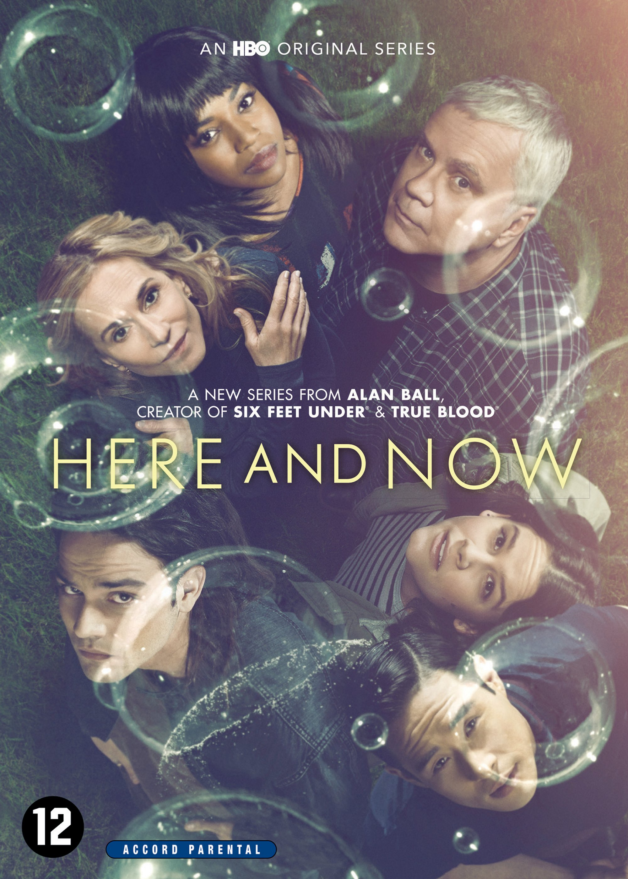 Pochette du DVD Here and Now avec un casting diversifié, des bulles et une superposition de texte sur de l'herbe.
