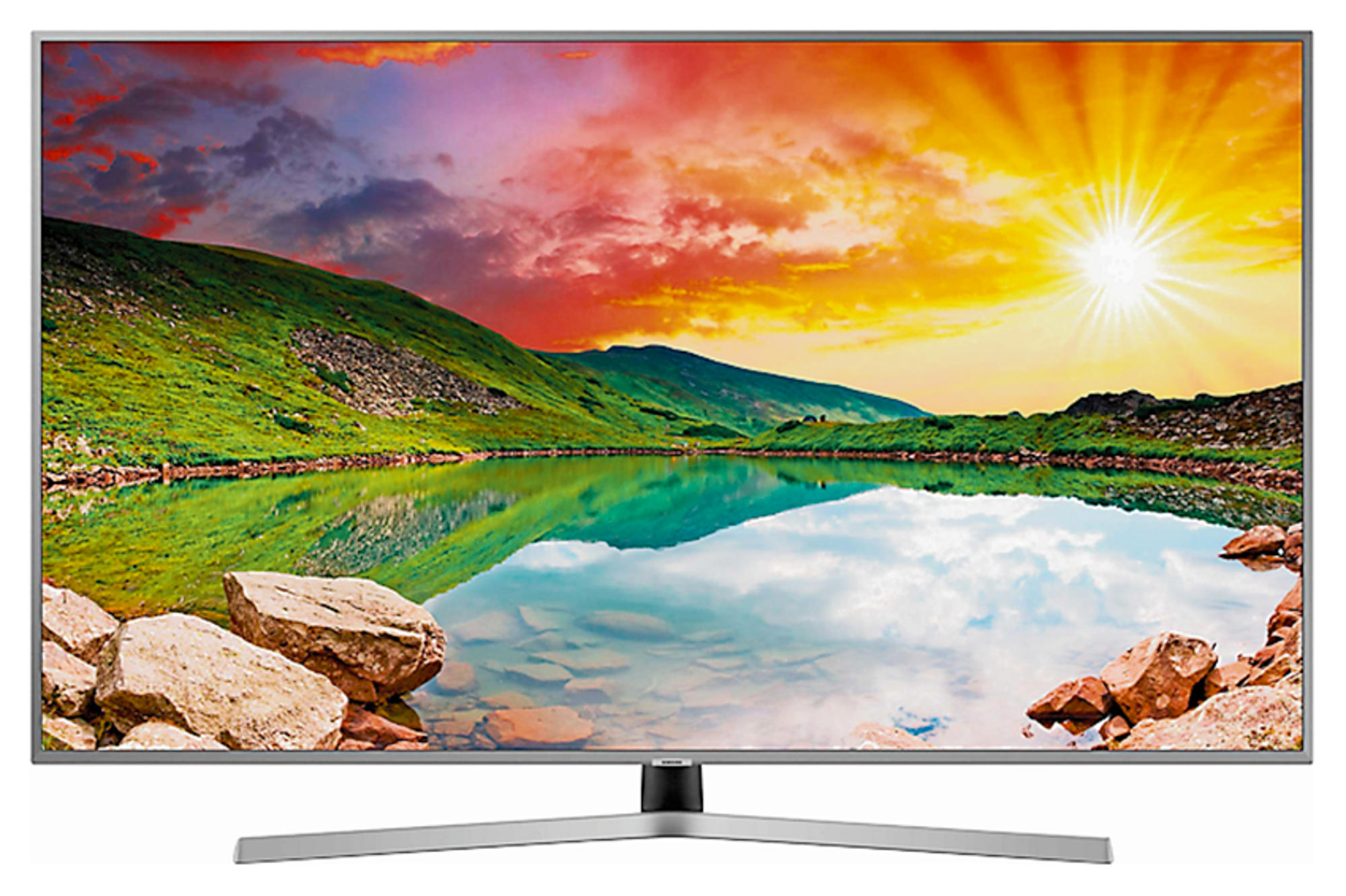 Un televisor de pantalla panorámica muestra un paisaje colorido con un lago y montañas bajo un atardecer.