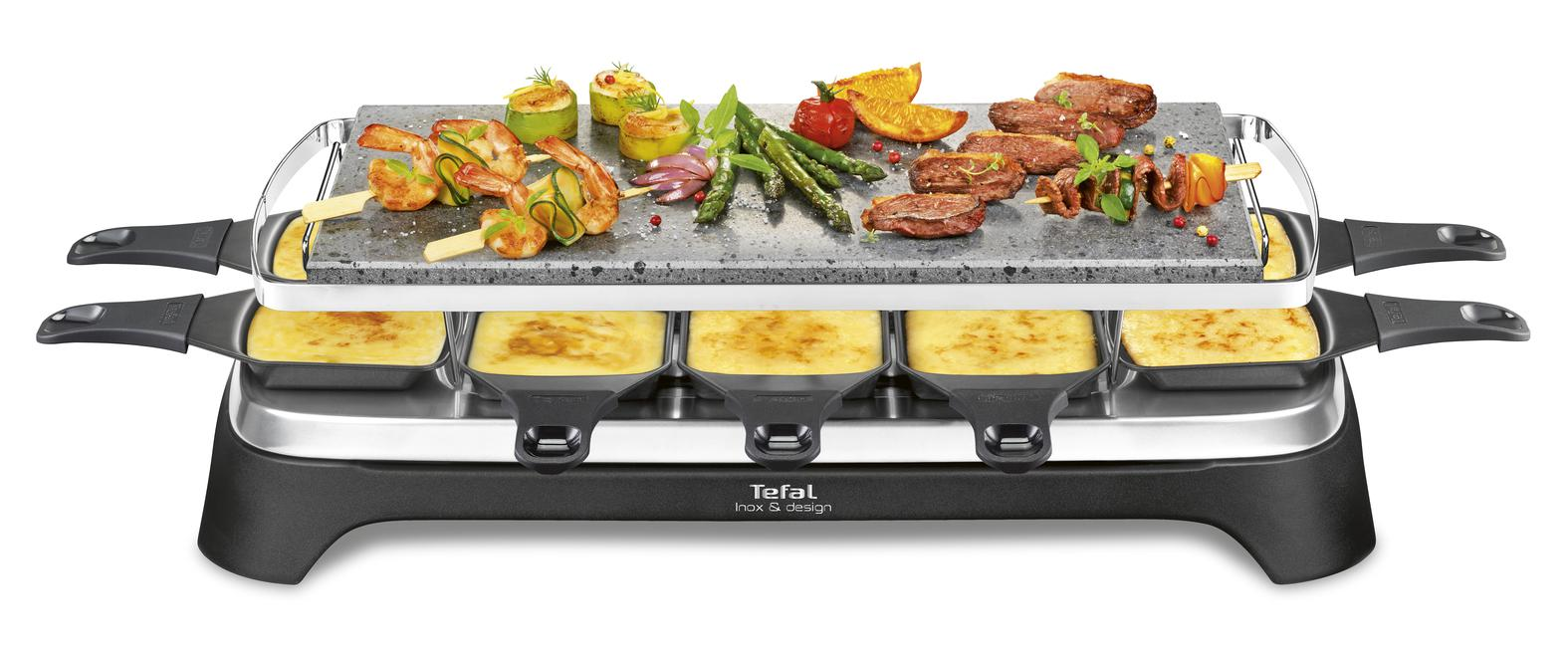Raclette grill met eten erop. Er zijn garnalen, groenten en vlees.