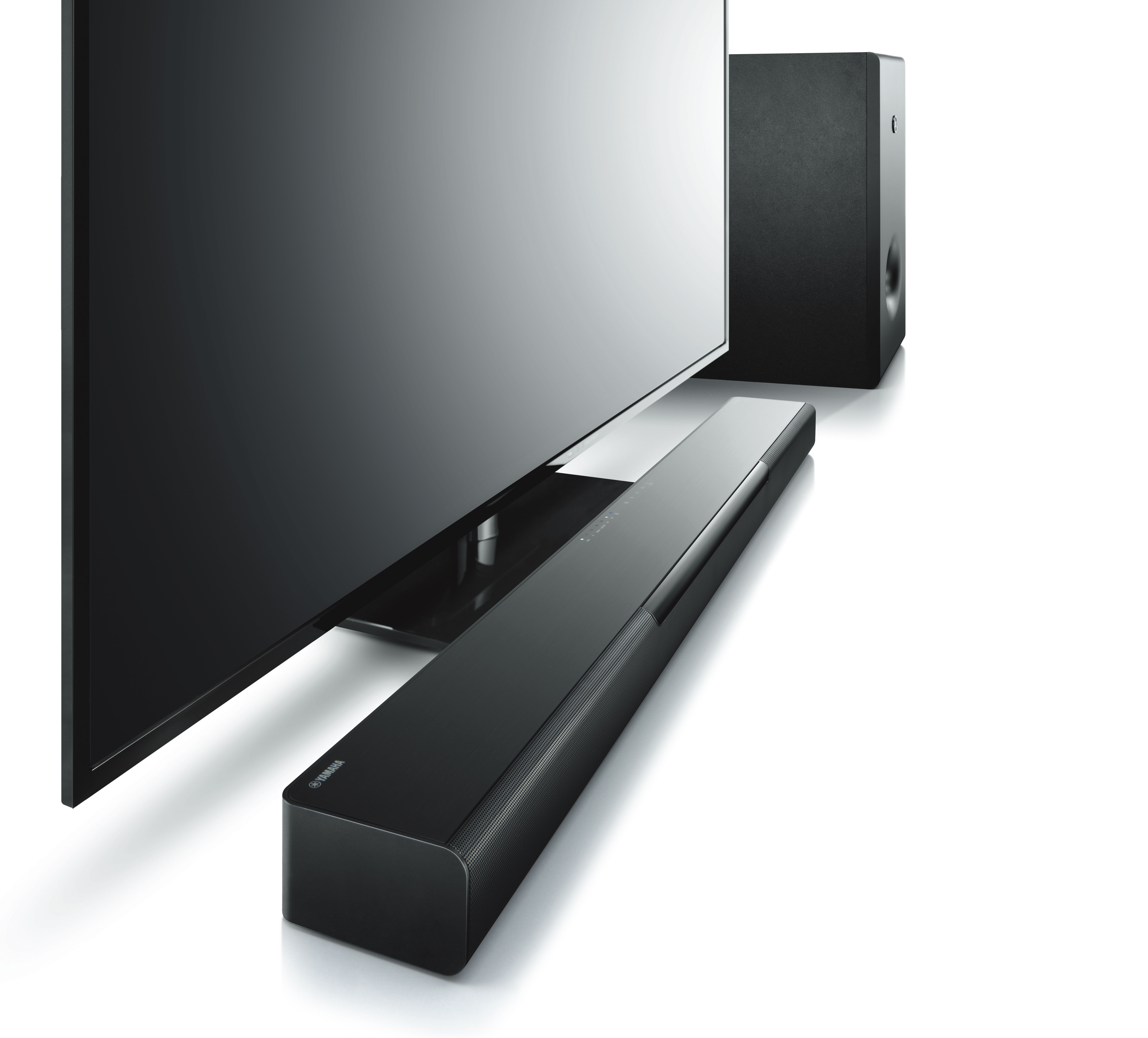 Ein Fernseher mit einer Soundbar darunter und einem Subwoofer. Alle sind schwarz und auf weißem Grund.