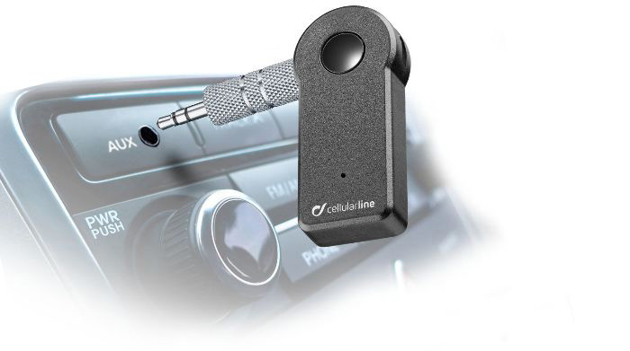Ein schwarzer Audioadapter mit Stecker, angeschlossen an den Audioeingang eines Autos.