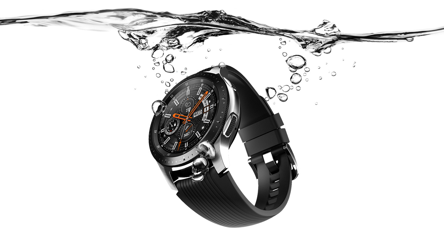 Smartwatch unter Wasser. Es hat ein schwarzes Armband und ein silbernes Gehäuse, mit Wassertröpfchen.