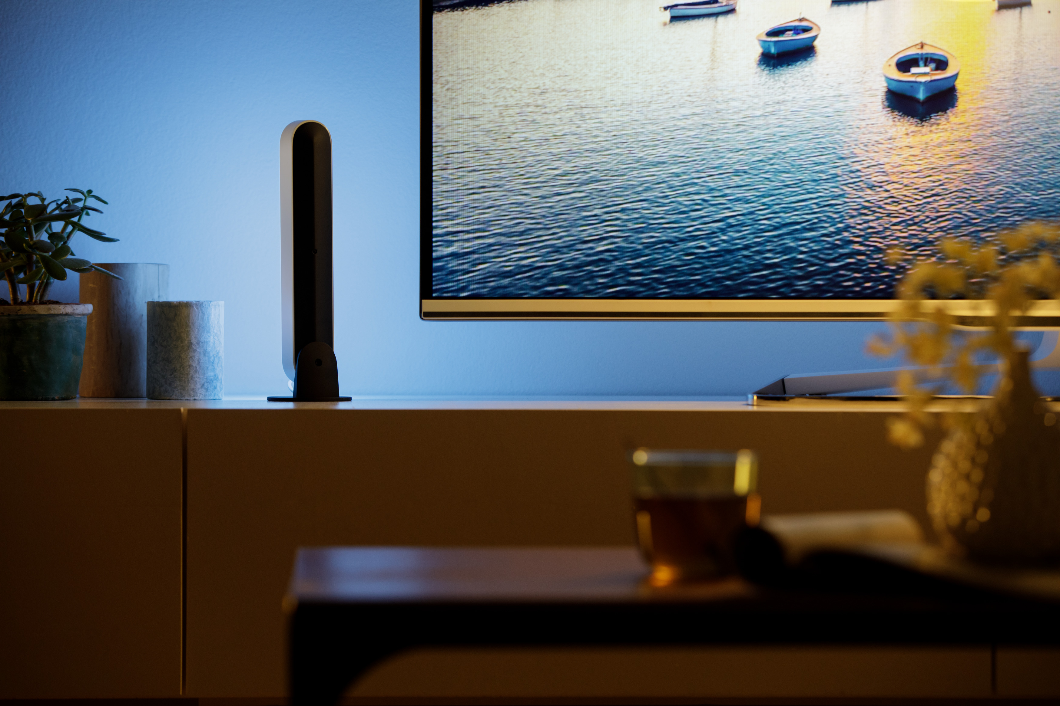 Una luce accanto a una televisione, con barche sullo sfondo.