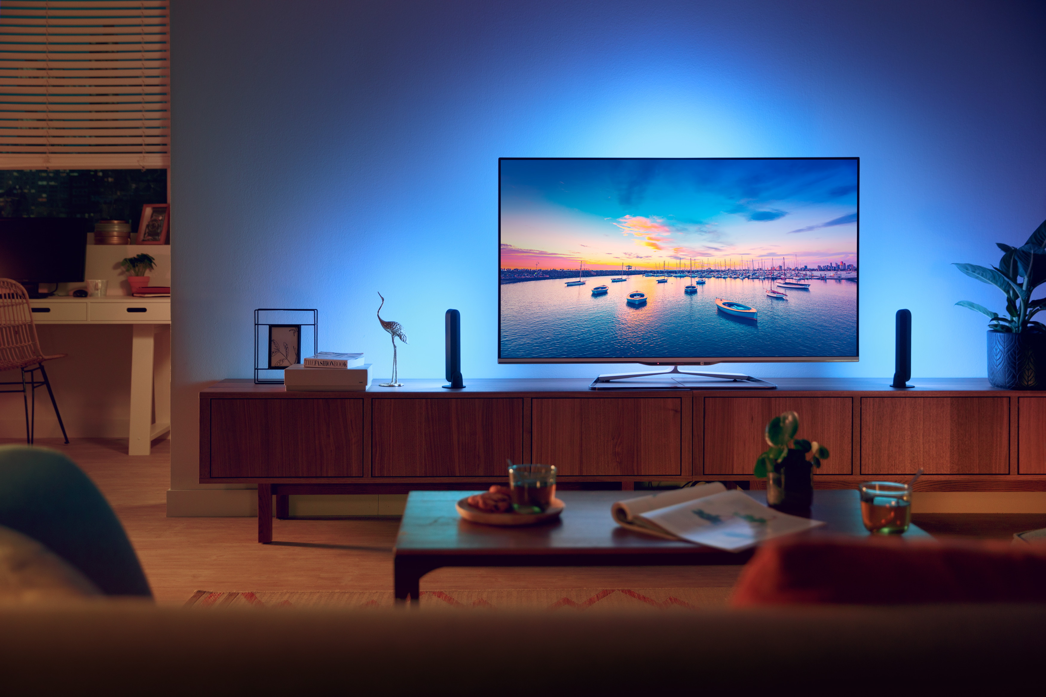 Soggiorno con TV su un mobile in legno, con illuminazione ambientale blu.