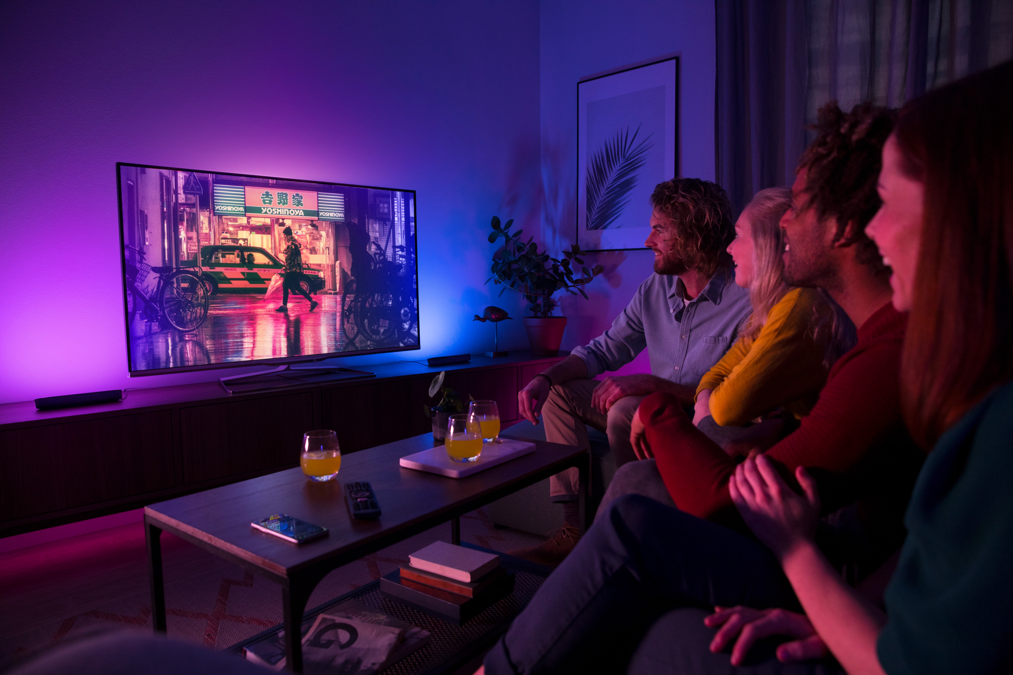 Gruppe von Leuten, die fernsehen. Der Fernseher zeigt eine Nachtszene.