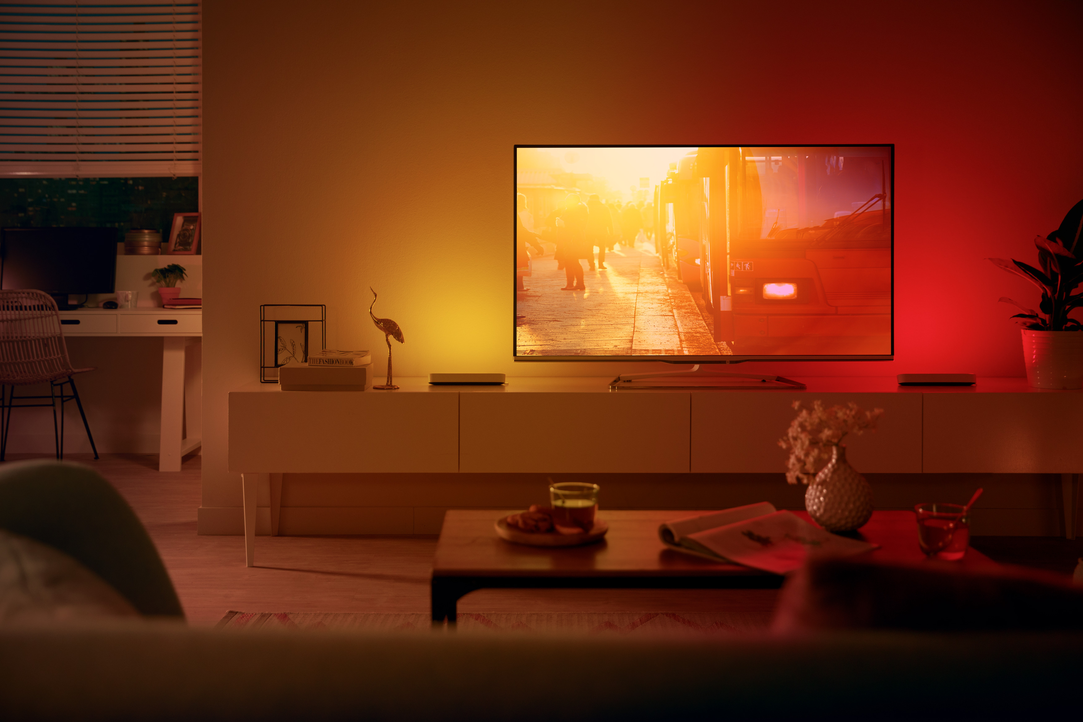 Wohnzimmer mit TV, das eine Stadtstraße zeigt. Warme Beleuchtung.