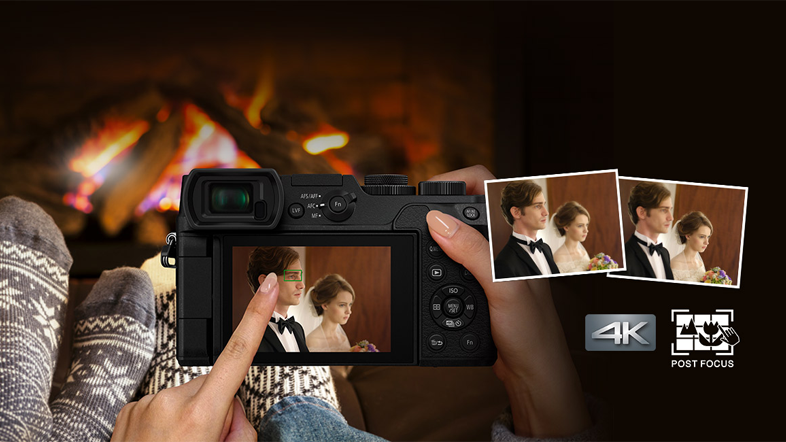 Egy személy kamerát tart, melyen egy pár képe látható, a kandalló mellett.