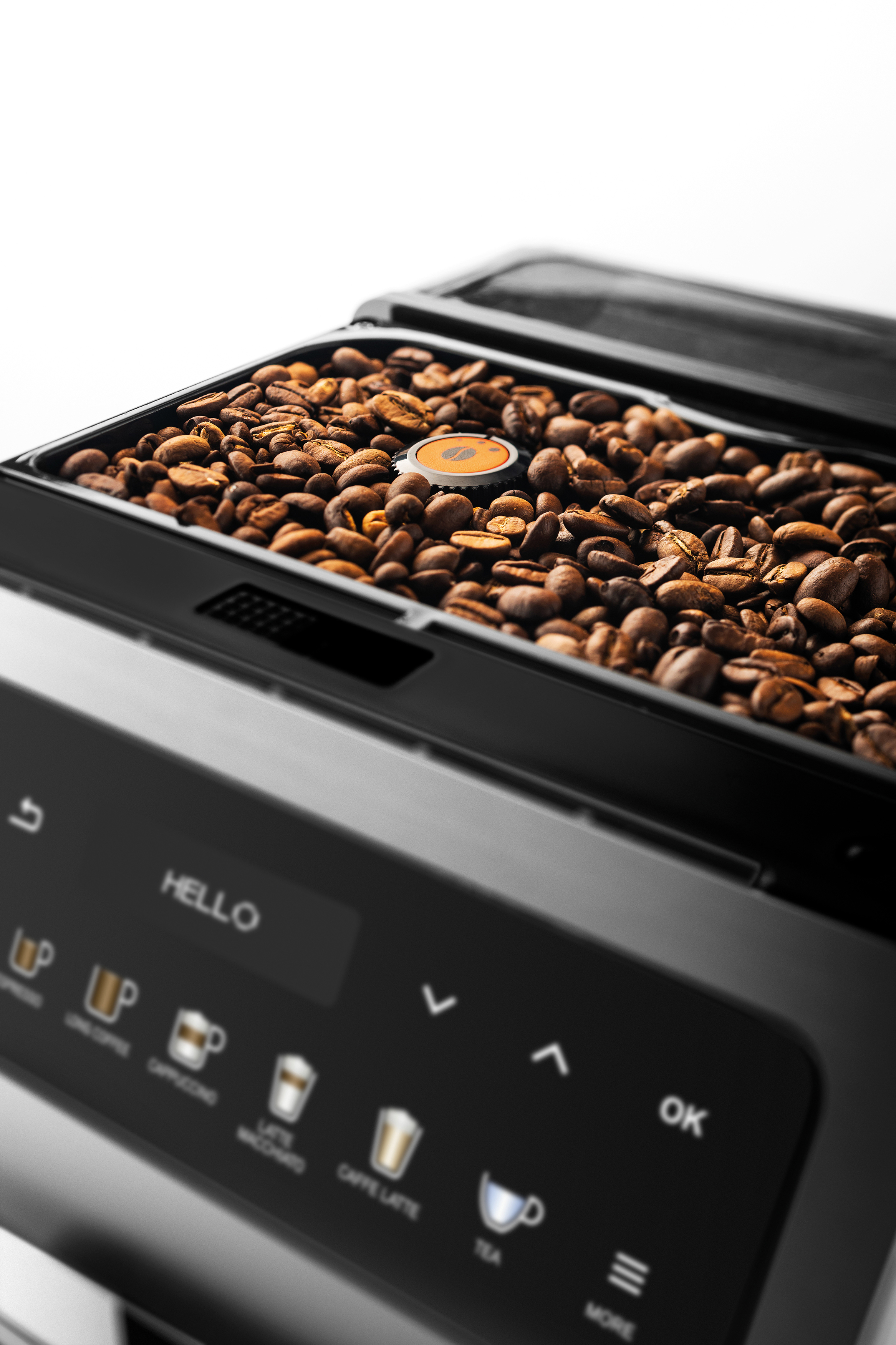 Nahaufnahme von Kaffeebohnen in einem Bohnenbehälter einer Kaffeemaschine, schwarz-weiß.