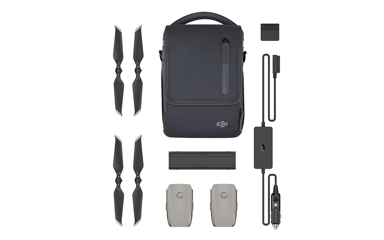 DJI Drohnenzubehör. Schwarze Tasche, Propeller, Batterien, Ladegerät und Ladekabel. Weißer Hintergrund.