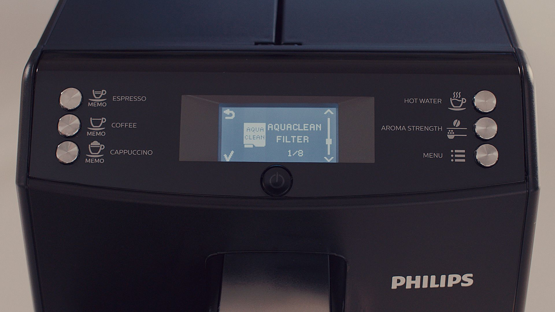 Gros plan sur l'écran d'une cafetière noire. L'écran affiche l'état du filtre Aquaclean.