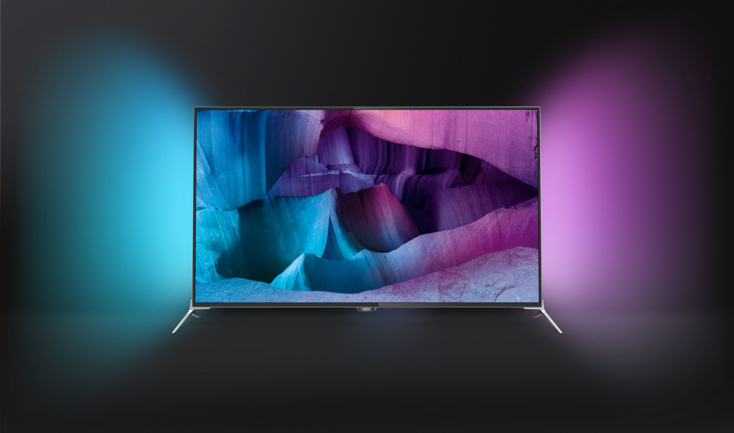 Un televisor moderno que muestra una escena de paisaje colorida, con iluminación ambiental azul y púrpura.