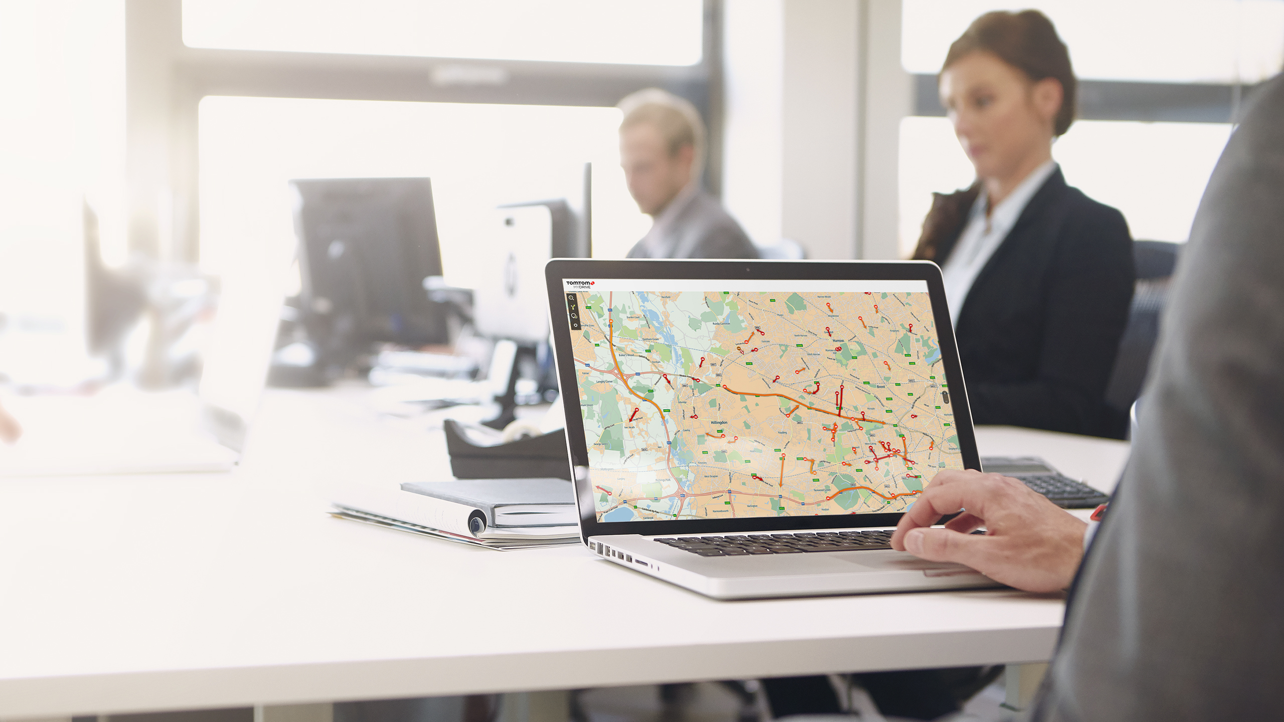 Una persona usando una laptop. La pantalla muestra un mapa de una ciudad con líneas rojas.
