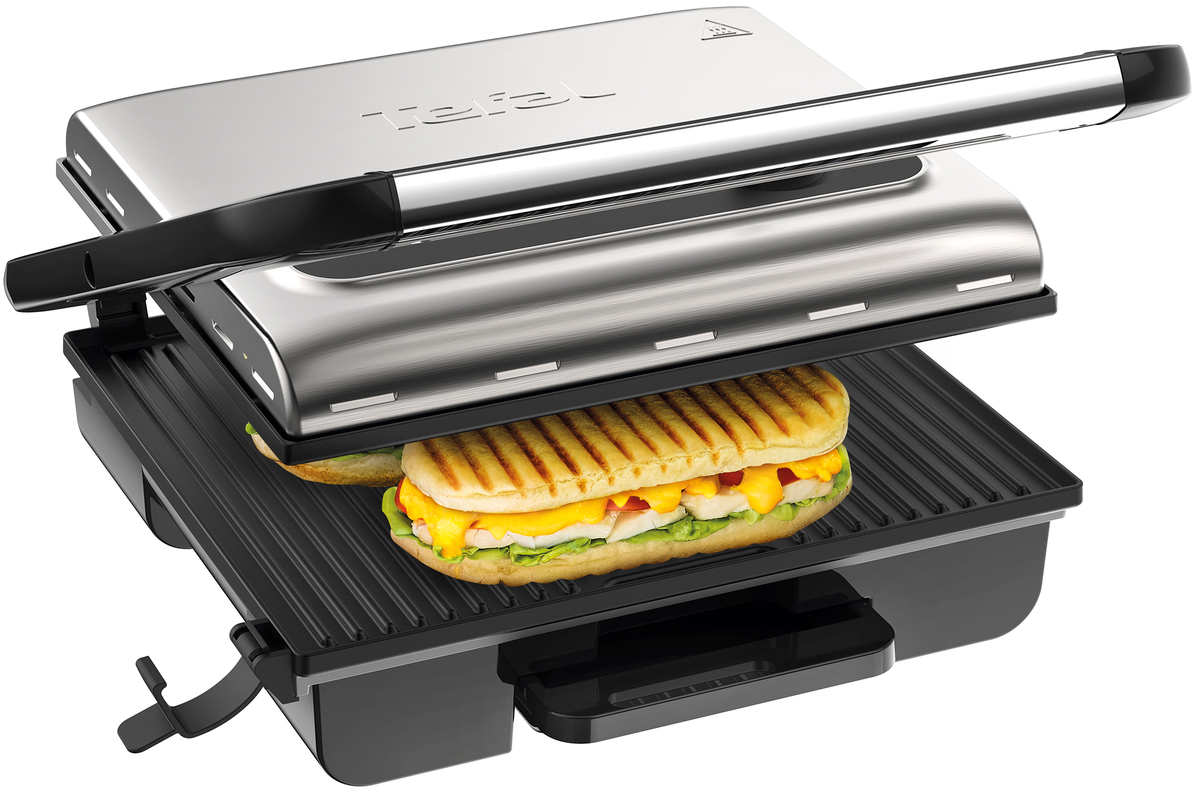 Une presse à panini avec un sandwich à l'intérieur. Design en acier inoxydable et noir. Le sandwich est grillé.