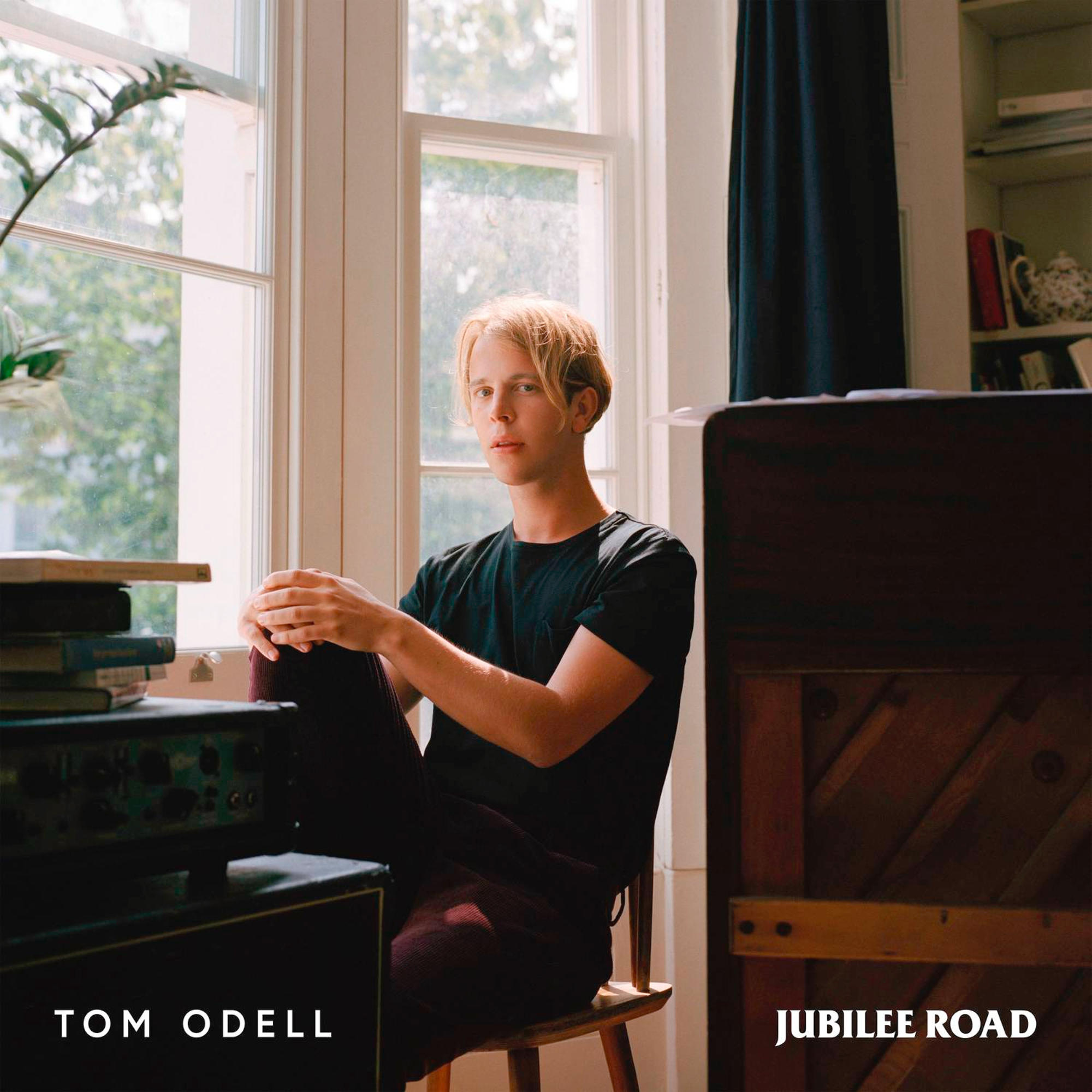 Tom Odell Albumcover. Mann sitzt am Fenster. Text sagt 'Tom Odell' und 'Jubilee Road'.