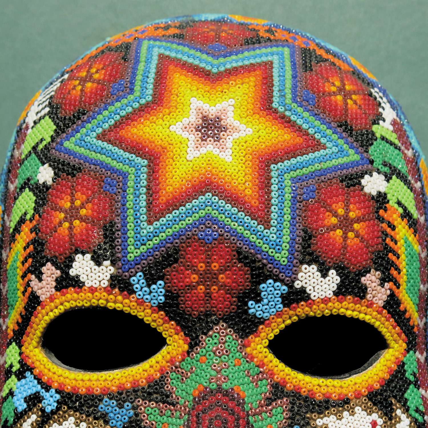 Eine Maske mit Perlen mit einem Stern-Design in der Mitte und floralen Mustern.